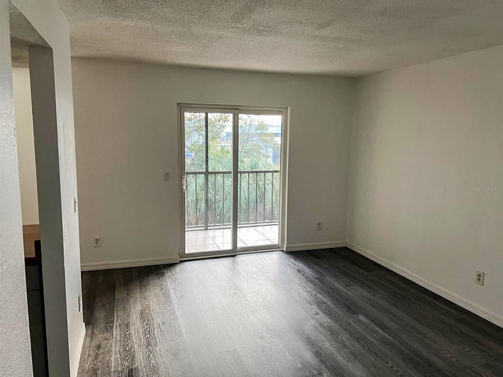9817 Turf Way, Unit GE Orlando, FL 32837 - Photo 6 of 19 a view of an empty room with wooden floor and a window