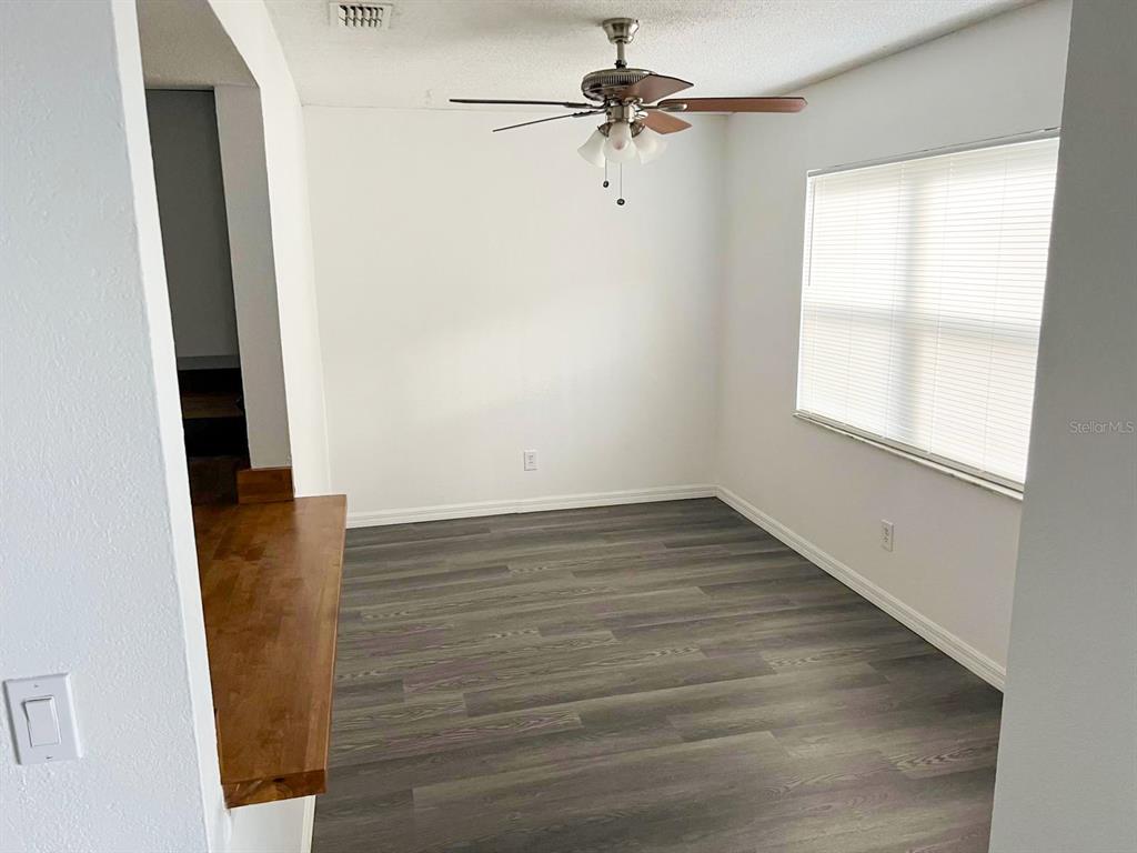 9817 Turf Way, Unit GE Orlando, FL 32837 - Photo 7 of 19 an empty room with wooden floor fan and windows