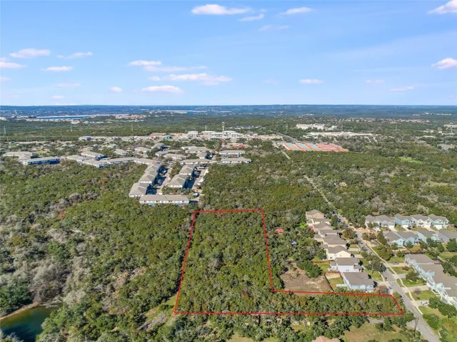 an aerial view of residential houses with outdoor space and trees