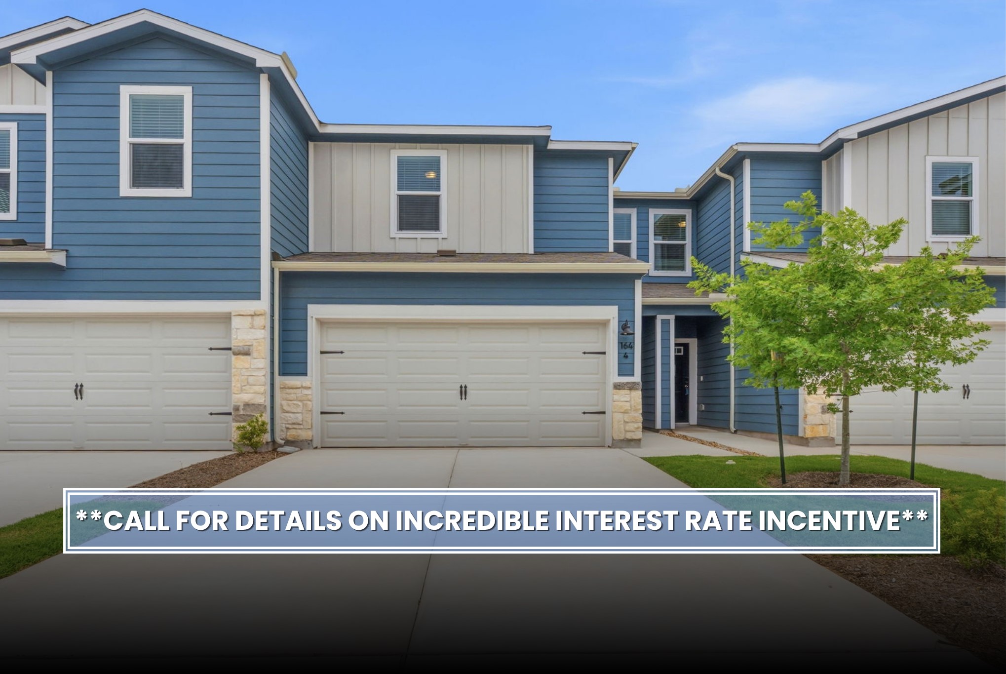 164 Cinnabar Lane, Unit 4 Kyle, TX 78640 - Photo 2 of 23 Modern townhome facade featuring a blue and white siding exterior, stone accents, two-car garage, and a concrete driveway