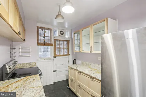 a kitchen with stainless steel appliances granite countertop a refrigerator and a stove top oven