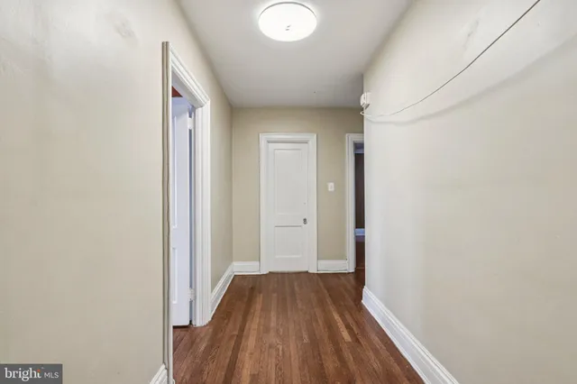 a view of a room with wooden floor and a bathroom