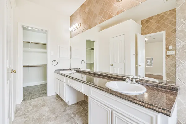 a bathroom with a granite countertop sink and a mirror