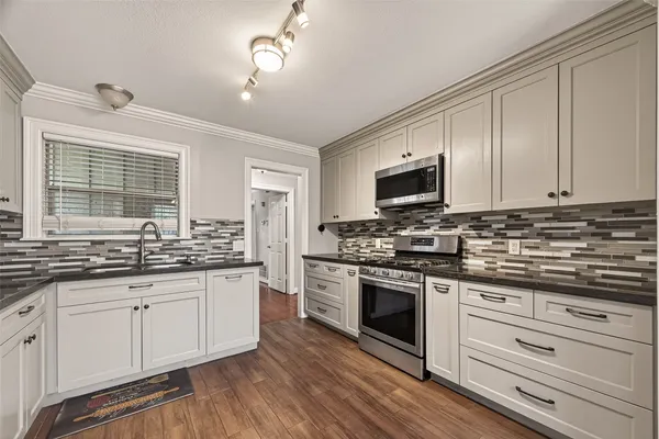a kitchen with stainless steel appliances granite countertop a stove and a sink