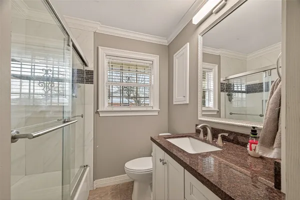 a bathroom with a granite countertop sink toilet and a mirror