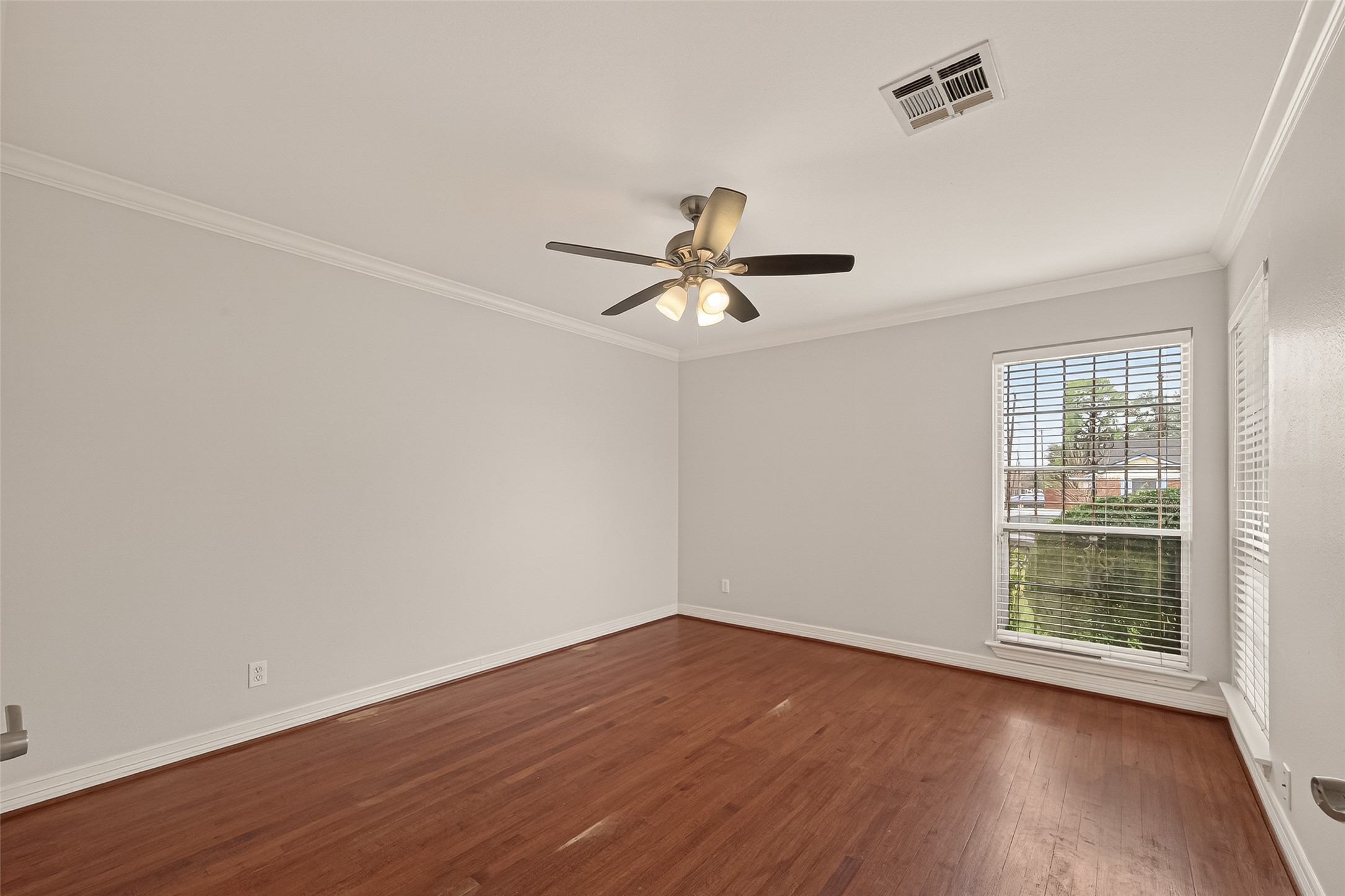 7702 Rockhill Street Houston, TX 77061 - Photo 21 of 30 an empty room with wooden floor and windows