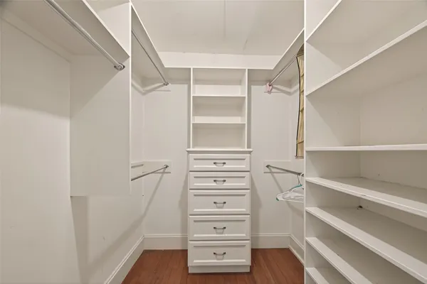 a view of walk in closet with empty racks