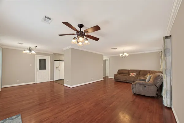 a living room with furniture and a wooden floor