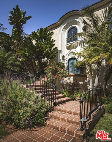 a view of a brick house with a small yard and plants