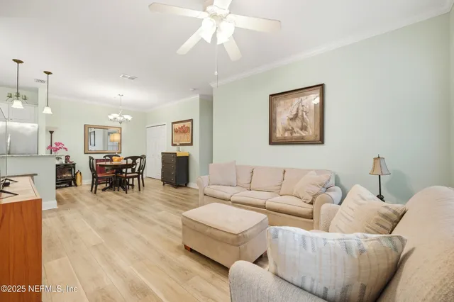 a living room with furniture and a dining table with kitchen view