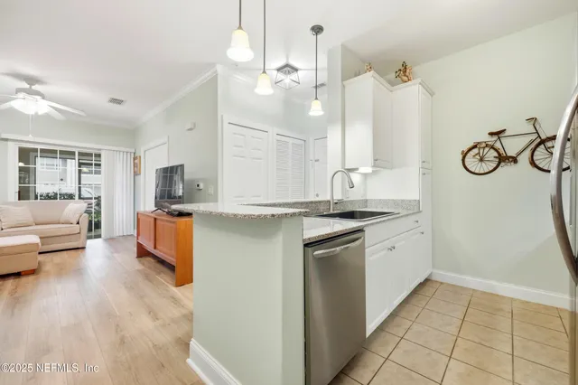 a kitchen with kitchen island granite countertop a sink cabinets and stainless steel appliances