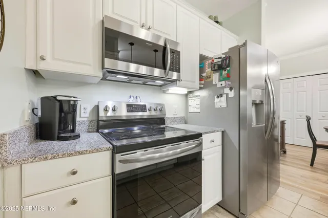 a kitchen with granite countertop a sink stove and refrigerator