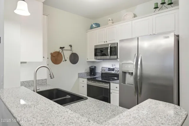 a kitchen with a sink stainless steel appliances and cabinets