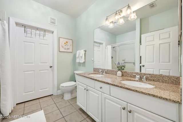 a bathroom with a granite countertop sink a toilet and a mirror