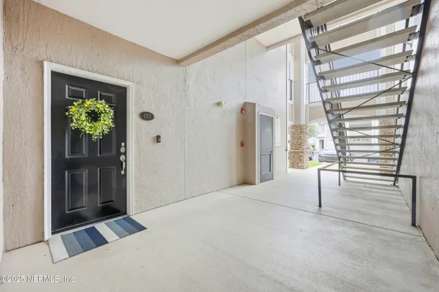 a view of an empty room with window and stairs