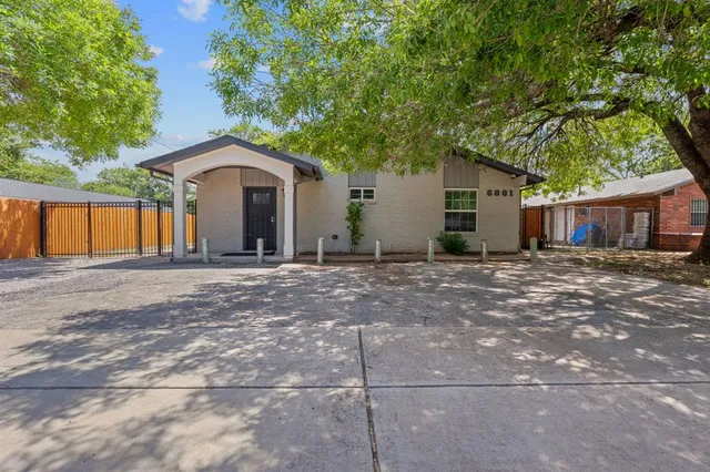 a view of a house with large windows and a small yard