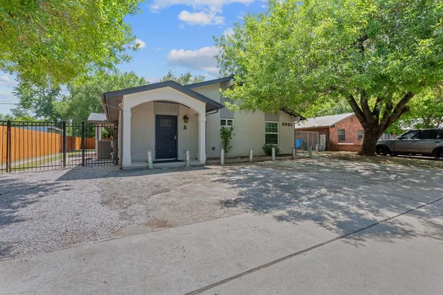 a view of a house with a yard and large tree