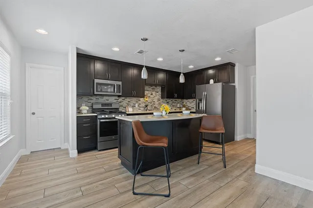 a kitchen with a refrigerator and a stove top oven