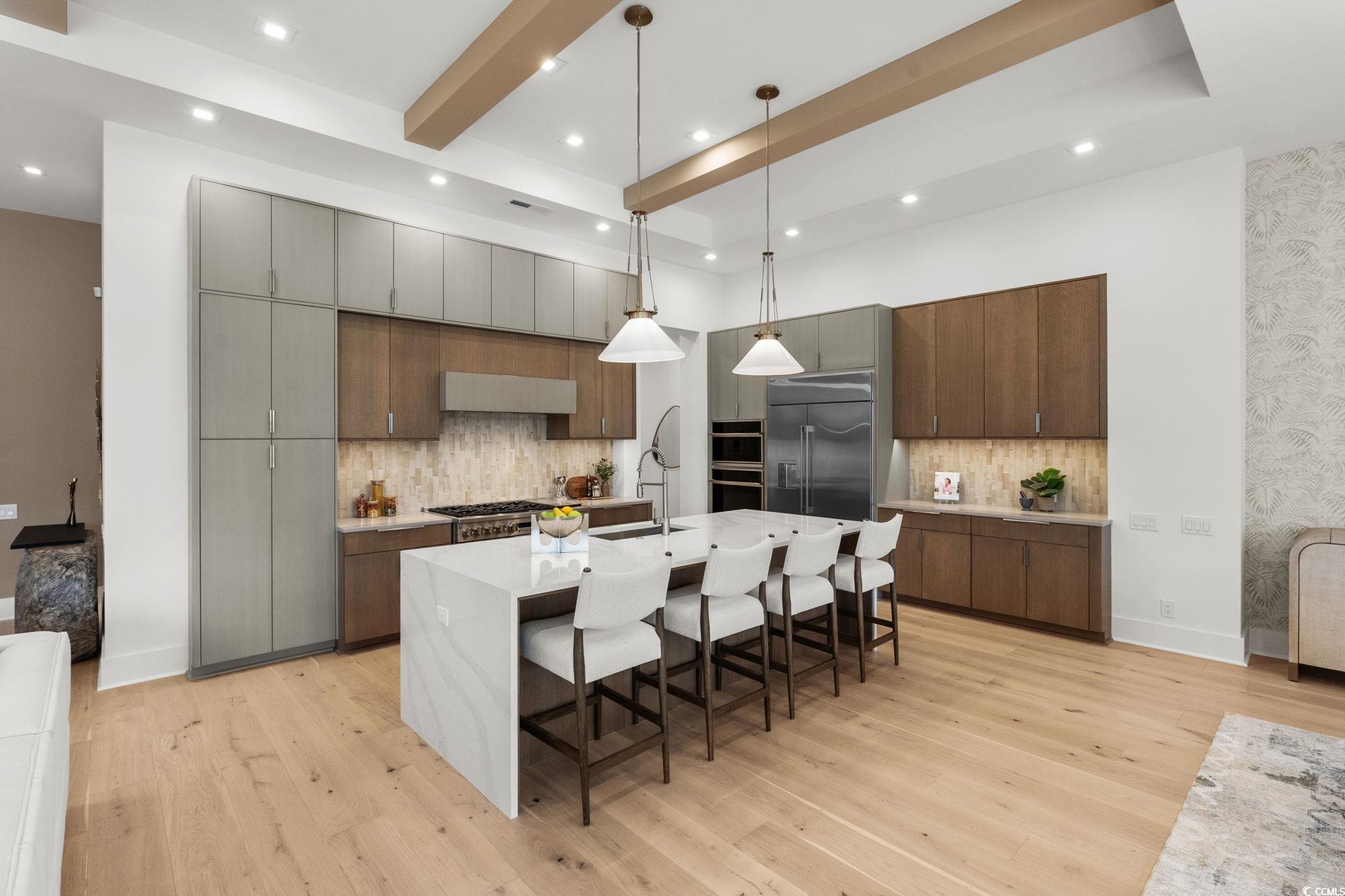 9273 Venezia Circle Myrtle Beach, SC 29579 - Photo 12 of 40 Kitchen featuring pendant lighting, a kitchen breakfast bar, modern cabinets, a center island with sink, and backsplash