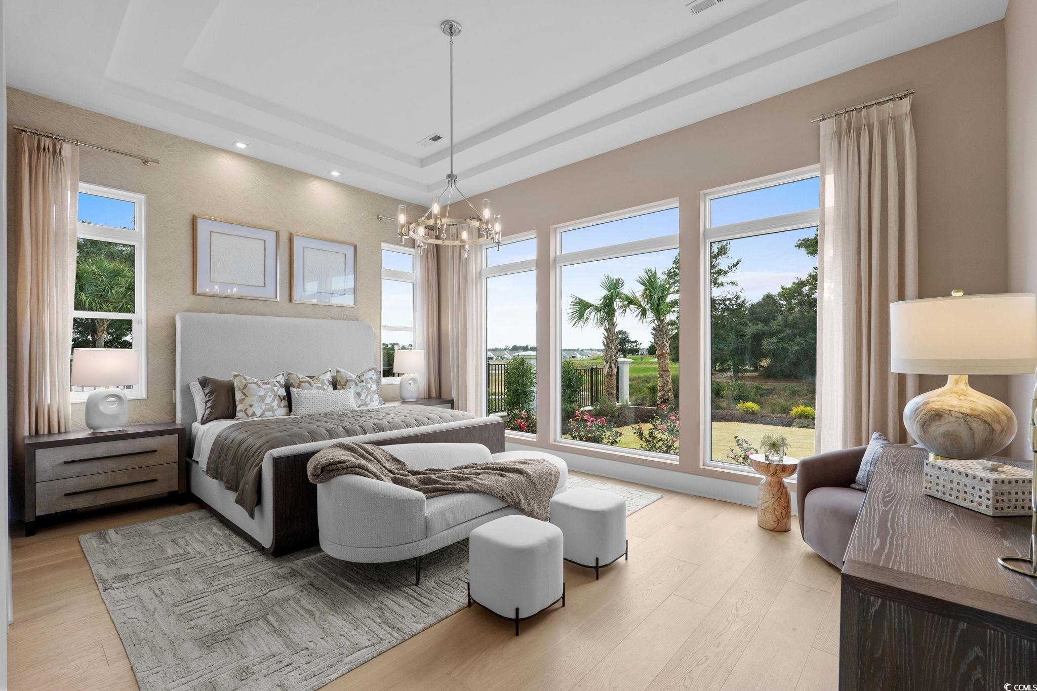 9273 Venezia Circle Myrtle Beach, SC 29579 - Photo 22 of 40 Bedroom featuring a raised ceiling, light wood finished floors, and a chandelier