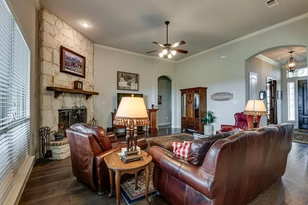 a living room with furniture a fireplace and a chandelier