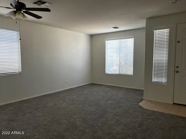 an empty room with a window and a fan