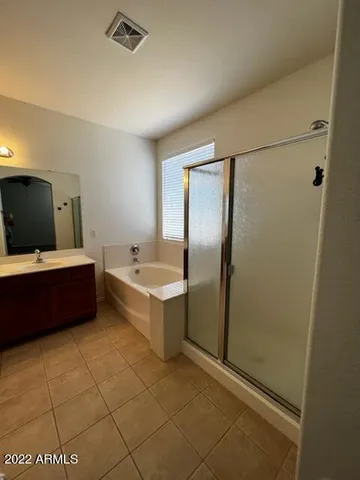 a bathroom with a tub sink and mirror