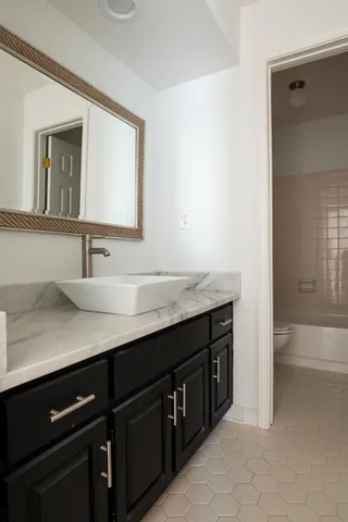 a bathroom with a granite countertop sink and a mirror