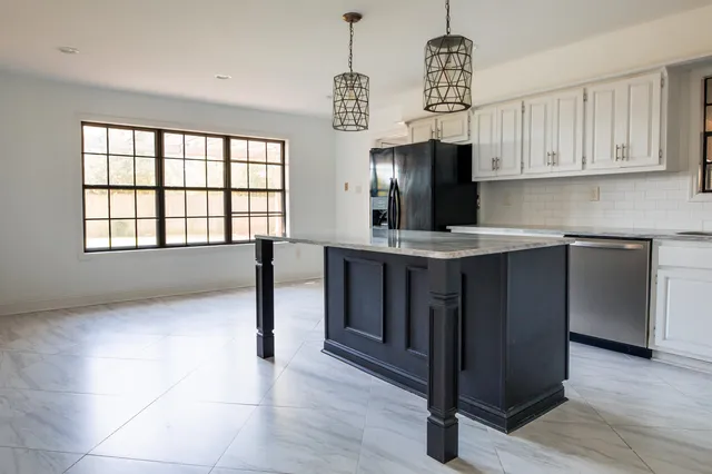 a kitchen with stainless steel appliances granite countertop a stove a sink and a refrigerator