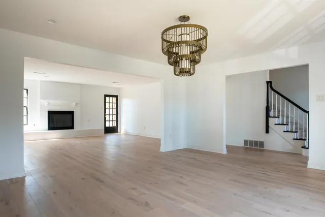 a view of empty room with wooden floor and fireplace