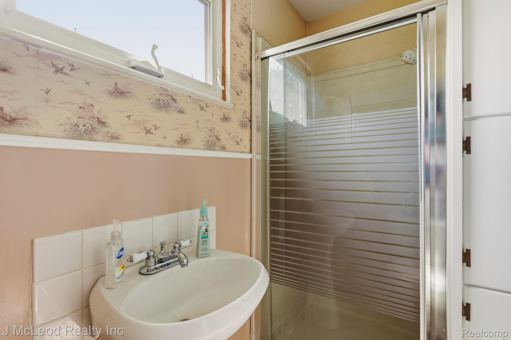 9481 Swaffer Road Vassar, MI 48768 - Photo 20 of 39 Wall-mounted sink with chrome faucet, tiled backsplash, and window with natural light