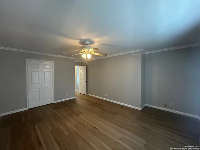 a view of an empty room with wooden floor