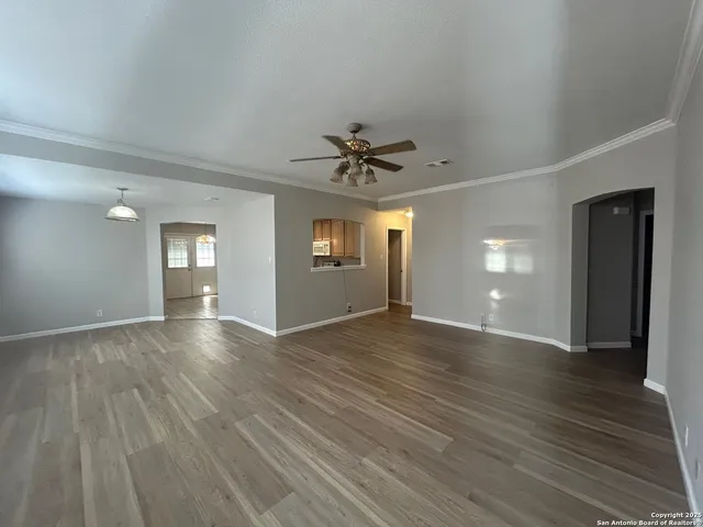 a view of a livingroom with wooden floor and a ceiling fan