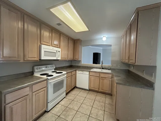 a kitchen with a stove sink and cabinets
