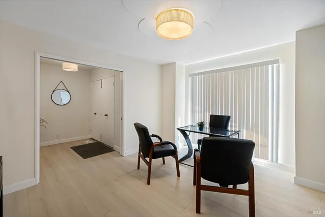 a view of a workspace with furniture and a window