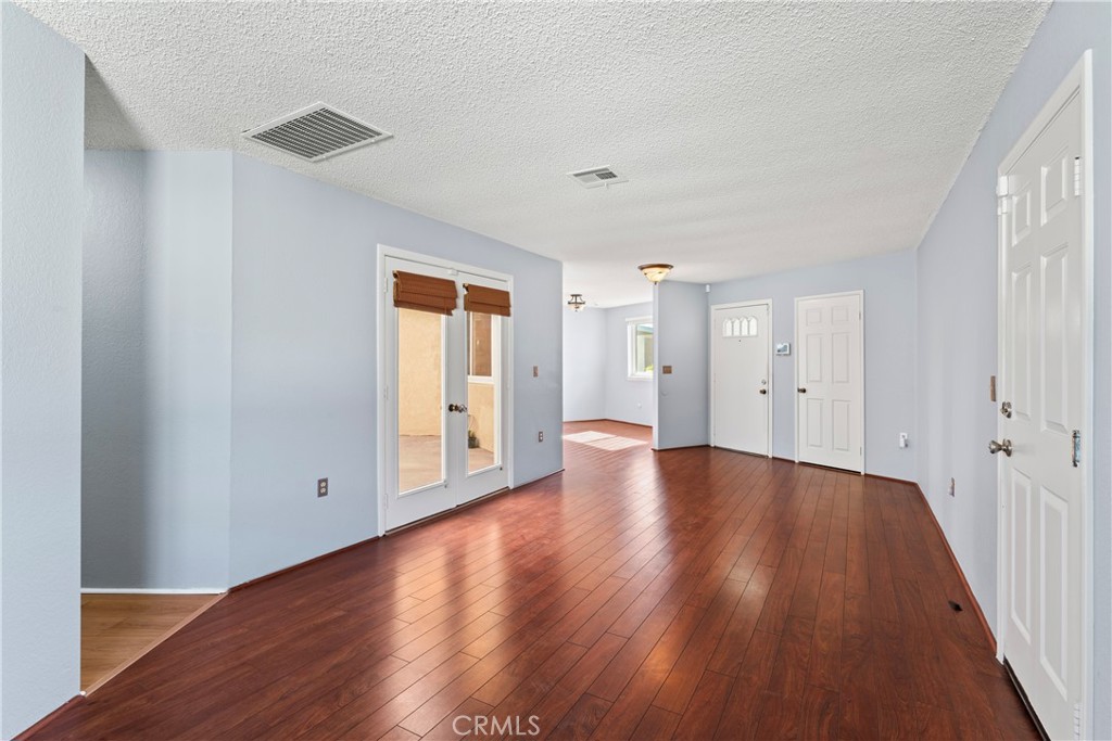 1068 Occidental Circle Redlands, CA 92374 - Photo 11 of 26 a view of an empty room with wooden floor and a window
