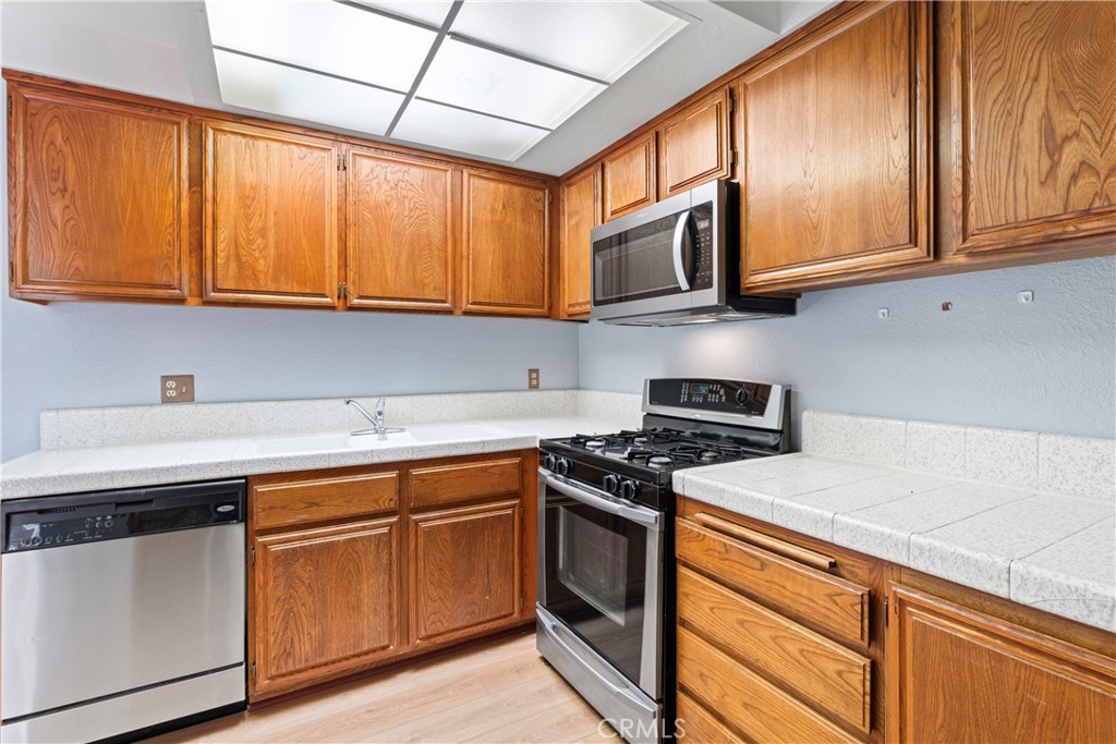1068 Occidental Circle Redlands, CA 92374 - Photo 4 of 26 a kitchen with stainless steel appliances granite countertop a sink a stove and cabinets