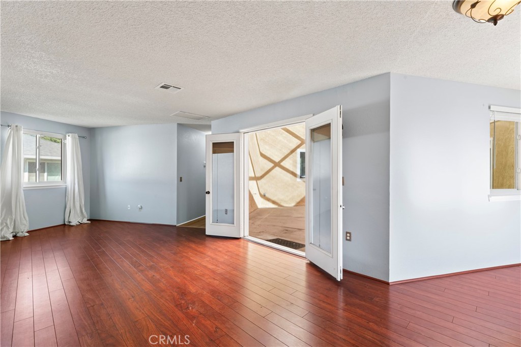 1068 Occidental Circle Redlands, CA 92374 - Photo 9 of 26 an empty room with wooden floor and windows