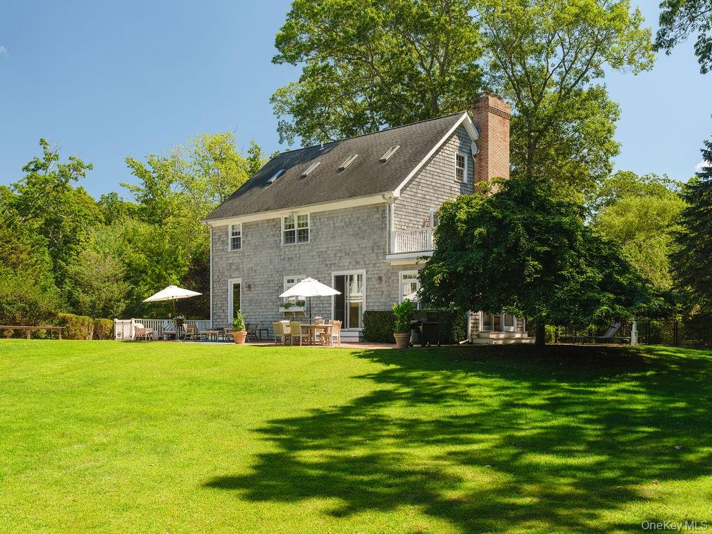 10947 North Bayview Road Southold, NY 11971 - Photo 13 of 43 Back of property with a lawn, a patio area, and a chimney