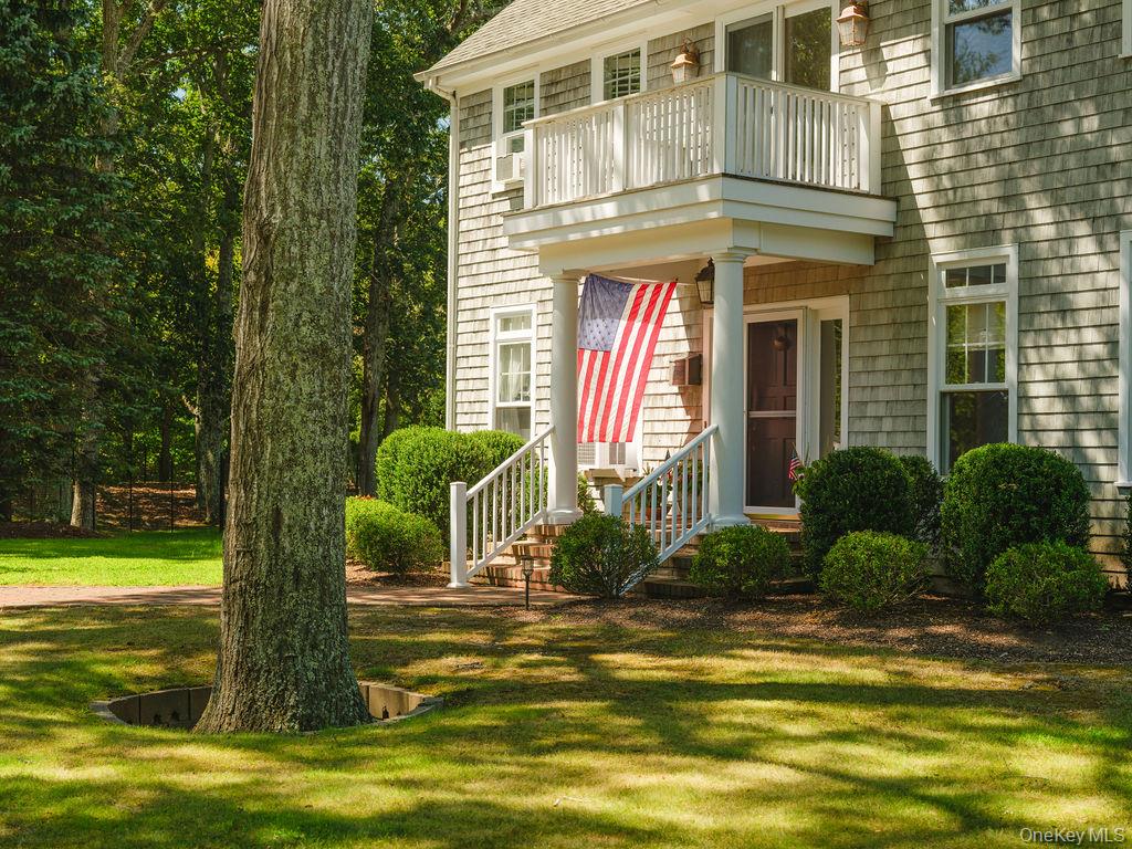 10947 North Bayview Road Southold, NY 11971 - Photo 2 of 43 View of exterior entry featuring a lawn and a shingled roof