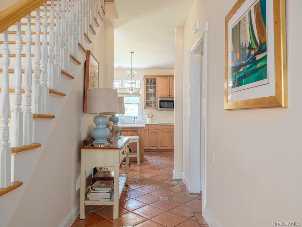 10947 North Bayview Road Southold, NY 11971 - Photo 21 of 43 Hallway with stairway and light tile patterned floors