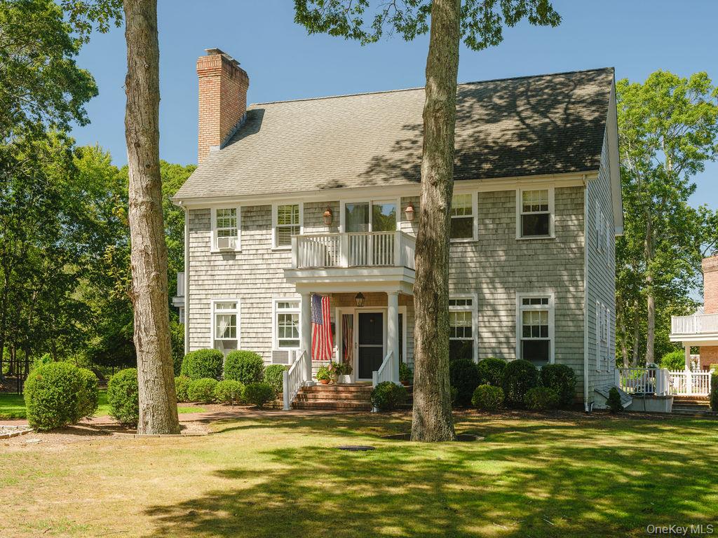 10947 North Bayview Road Southold, NY 11971 - Photo 3 of 43 Colonial house with a balcony, a front lawn, a shingled roof, and a chimney