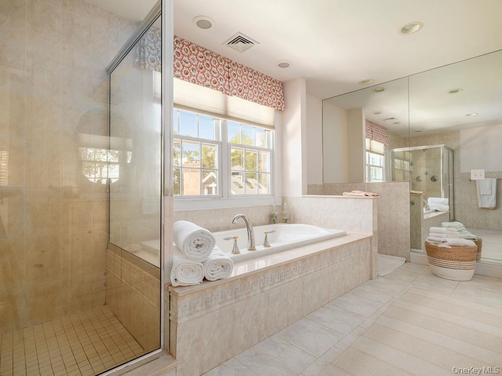 10947 North Bayview Road Southold, NY 11971 - Photo 31 of 43 Bathroom featuring light tile patterned flooring, a garden tub, and a shower stall