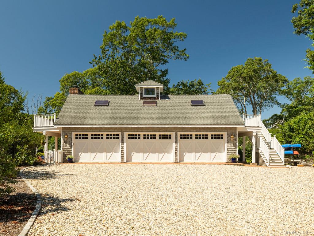 10947 North Bayview Road Southold, NY 11971 - Photo 5 of 43 View of front of property with roof with shingles, stairway, a garage, and gravel driveway