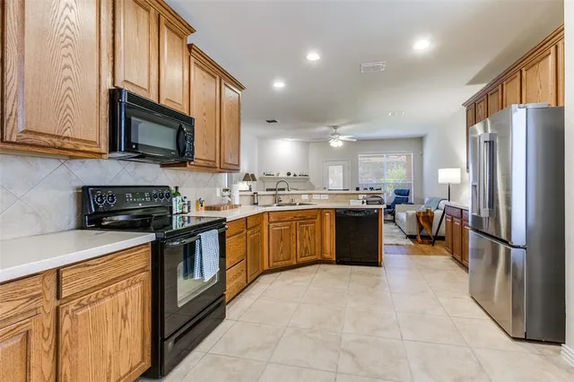 a kitchen with stainless steel appliances granite countertop a refrigerator a sink a stove a microwave and a refrigerator