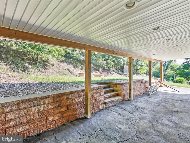 a view of an empty room with wooden floor and outdoor space