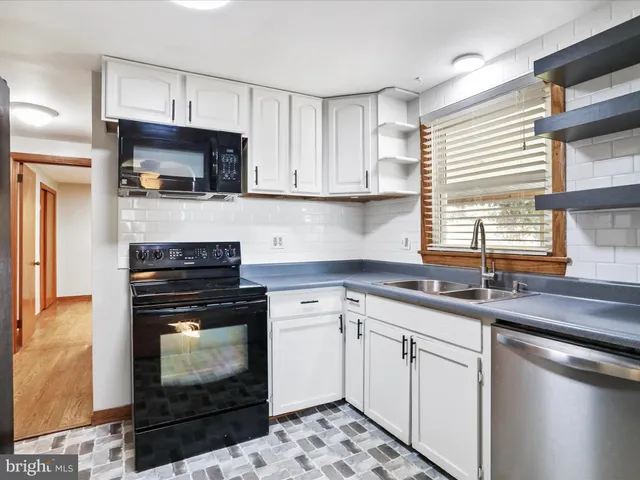 a kitchen with cabinets appliances a sink and a window