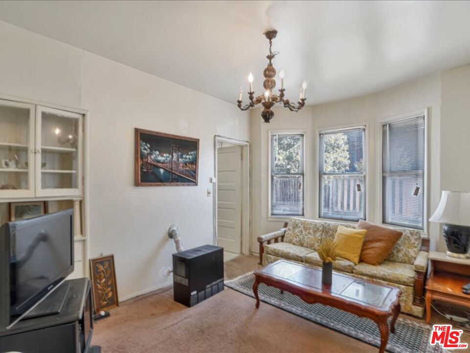 2057 Emerson Street Berkeley, CA 94703 - Photo 5 of 37 a living room with furniture a chandelier and a window