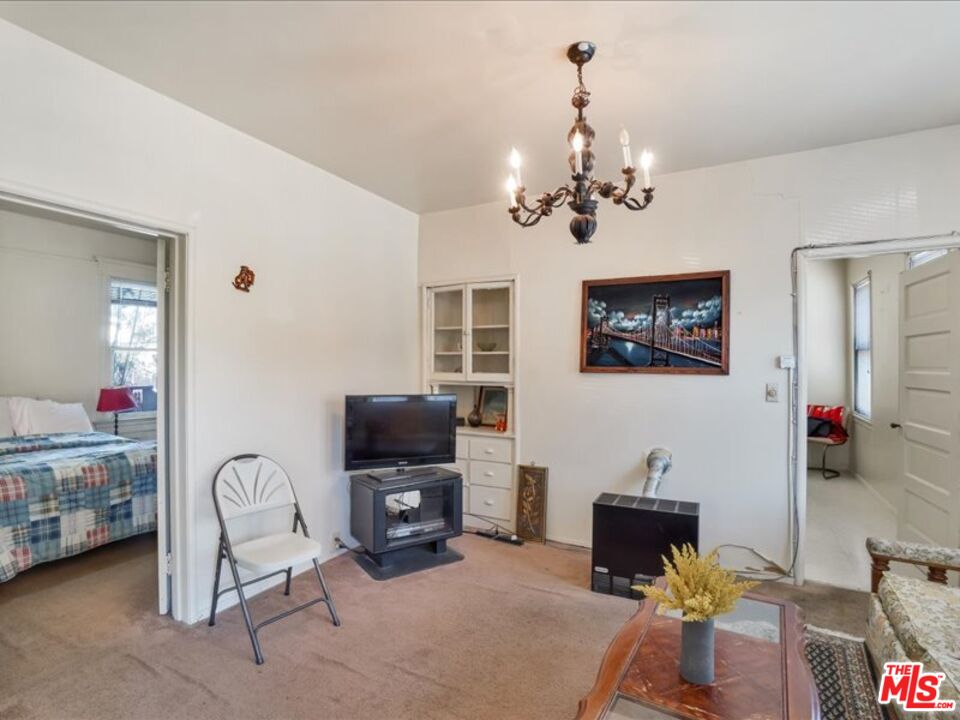 2057 Emerson Street Berkeley, CA 94703 - Photo 7 of 37 a living room with furniture a chandelier and a flat screen tv