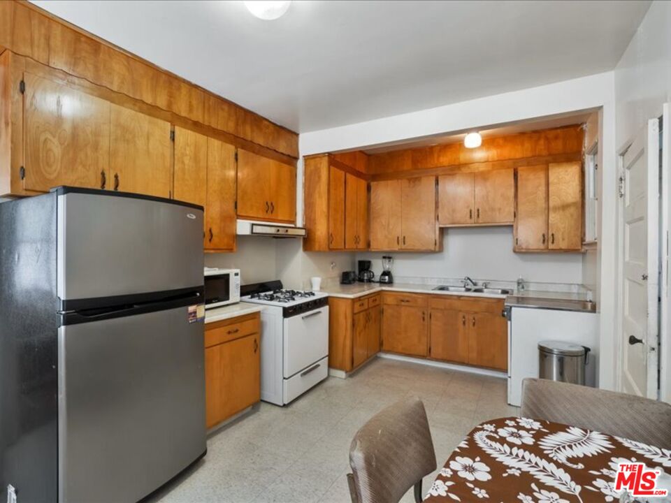 2057 Emerson Street Berkeley, CA 94703 - Photo 9 of 37 a kitchen with stainless steel appliances granite countertop a refrigerator a sink dishwasher a stove with wooden cabinets and floor